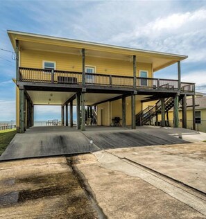 A two-story building with a balcony and a covered outdoor area. - Waterfront Property with a 300ft Pier w/ Fishing Lights (Dickinson)