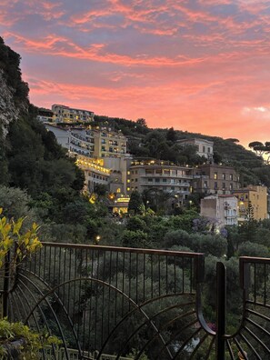 Una zona residencial en una ladera con edificios, algunos con balcones, y una barandilla en primer plano.