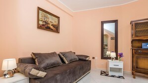 A modern room with a brown sofa, a small white nightstand, a mirror, and a wooden cabinet. - Cozy apartment in Matulji with WiFi (Matulji)