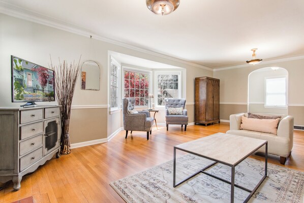 A living room with a sofa, armchair, coffee table, and a cabinet.