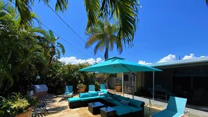 A patio area with a sectional sofa, lounge chairs, and a large umbrella. - Deerfield Beach House and Pool
https://my.matterport.com/show/?m=6txjncxb5Lo (Deerfield Beach)