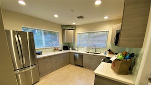 A modern kitchen with stainless steel appliances, a granite countertop, and a large window. - Deerfield Beach House and Pool
https://my.matterport.com/show/?m=6txjncxb5Lo (Deerfield Beach)