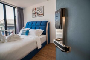 Habitación de hotel con cama, panel de control en la pared y vistas por la ventana.