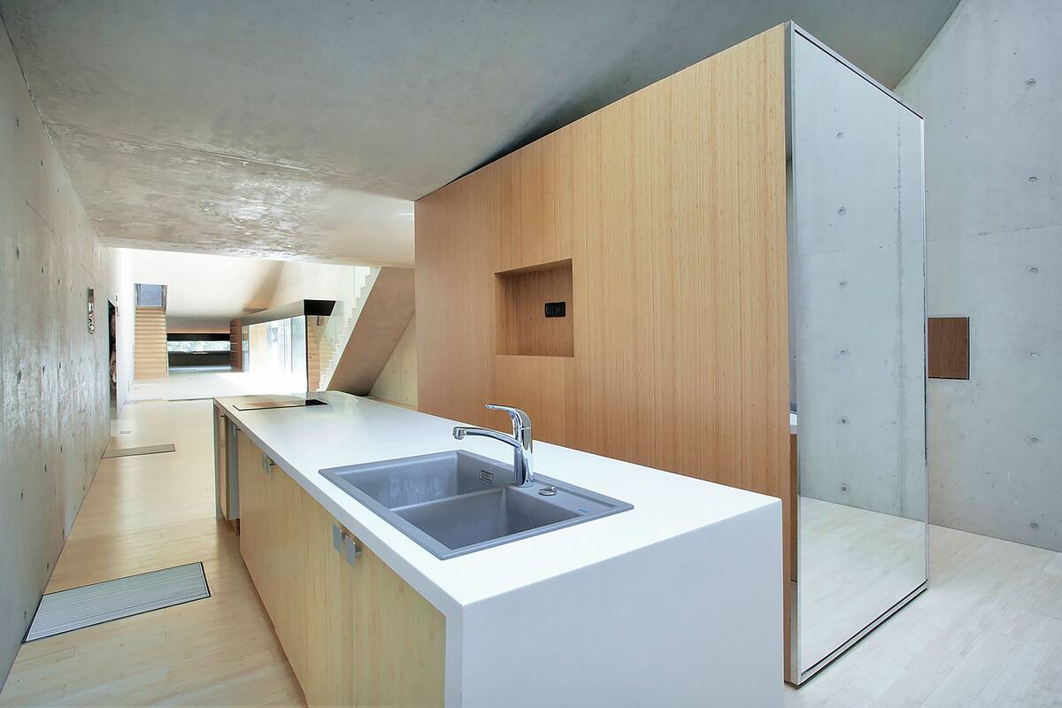 Una cocina moderna con una isla grande, un lavabo doble y una pared de acento de madera.