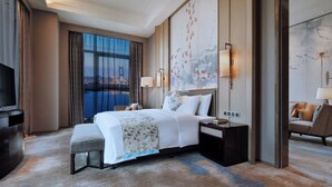 A modern hotel room with a large bed, a desk, a chair, and a television. - Wanda Realm Huangshi (Huangshi)