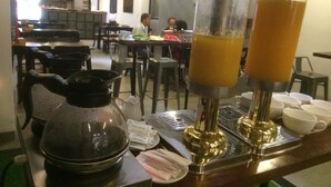 A restaurant setting with a coffee machine, a kettle, and a juice dispenser on the counter. - Kha Hotel - Hostel (Hue)