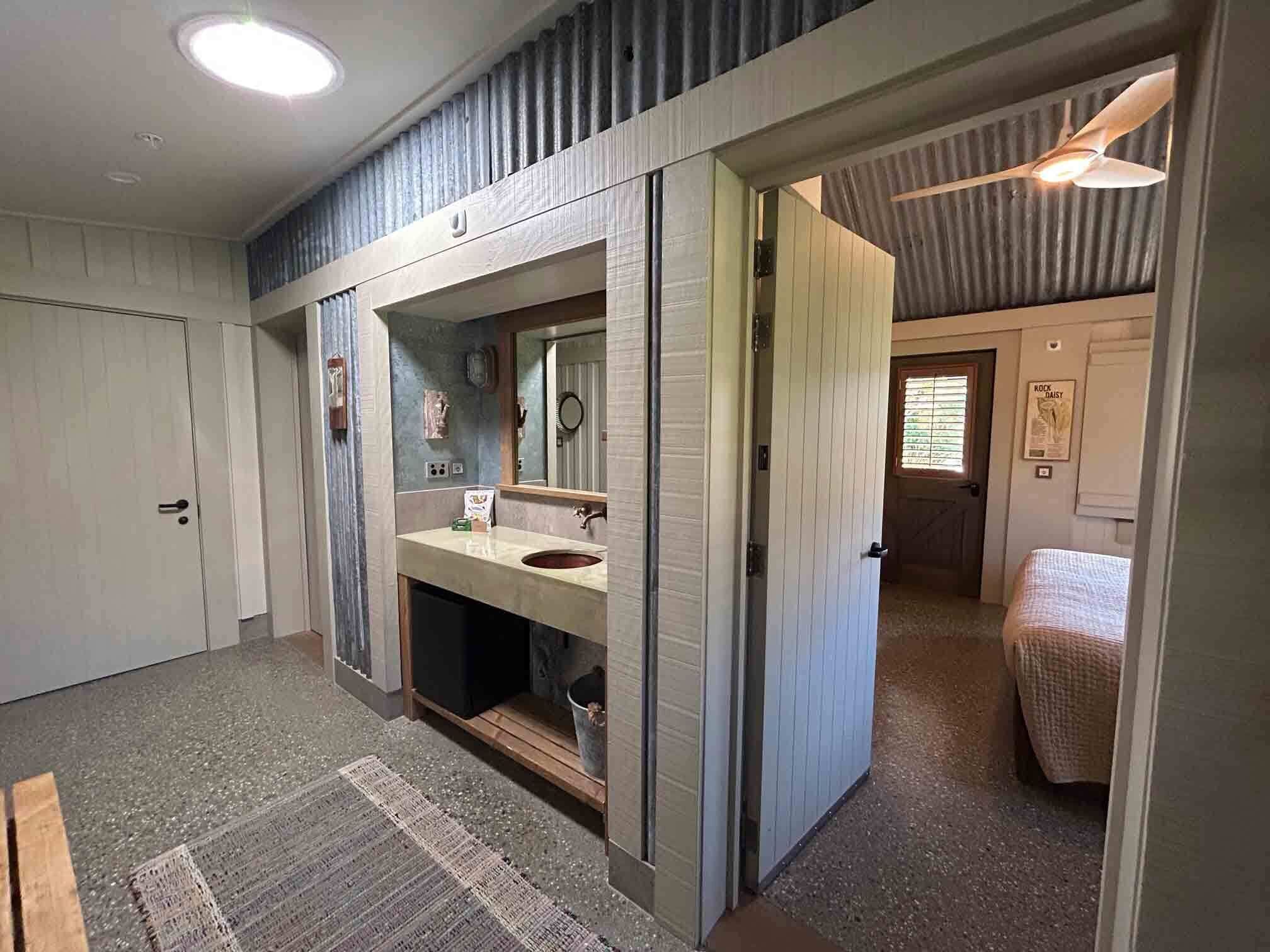 A bathroom with a sink, mirror, and toilet.