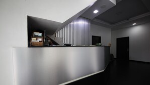 Una moderna recepción con un acabado metálico elegante e incorporada una lámpara de escritorio.