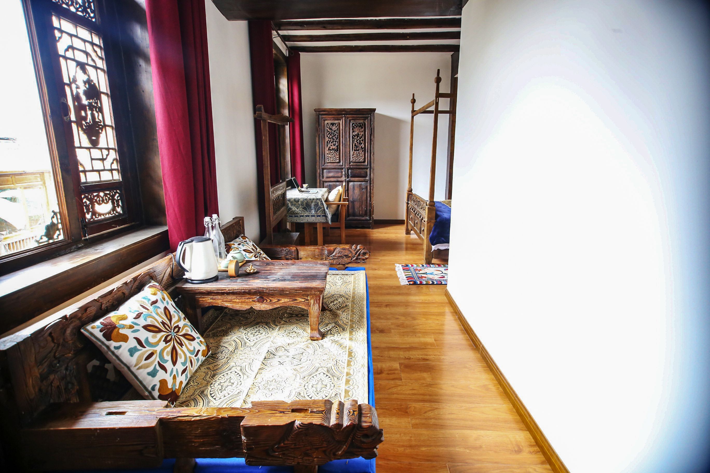 Una habitación tradicional con un banco de madera, una mesa y un armario.