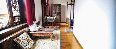 Una habitación tradicional con un banco de madera, una mesa y un armario.