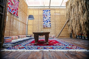 A traditional room with a wooden floor, a central table, and a red carpet. - Energy Healing Space Inn (Deqin)