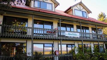 Alpine Chalets offers a traditional two-story retreat with a balcony and multiple windows.