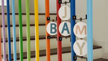 A staircase with colorful vertical bars and circular signs with letters.