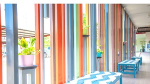 Un couloir agrémenté de panneaux verticaux aux couleurs vives et de bancs.