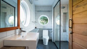 A modern bathroom with a large sink, toilet, and shower area.