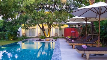 Una piscina al aire libre, tumbonas