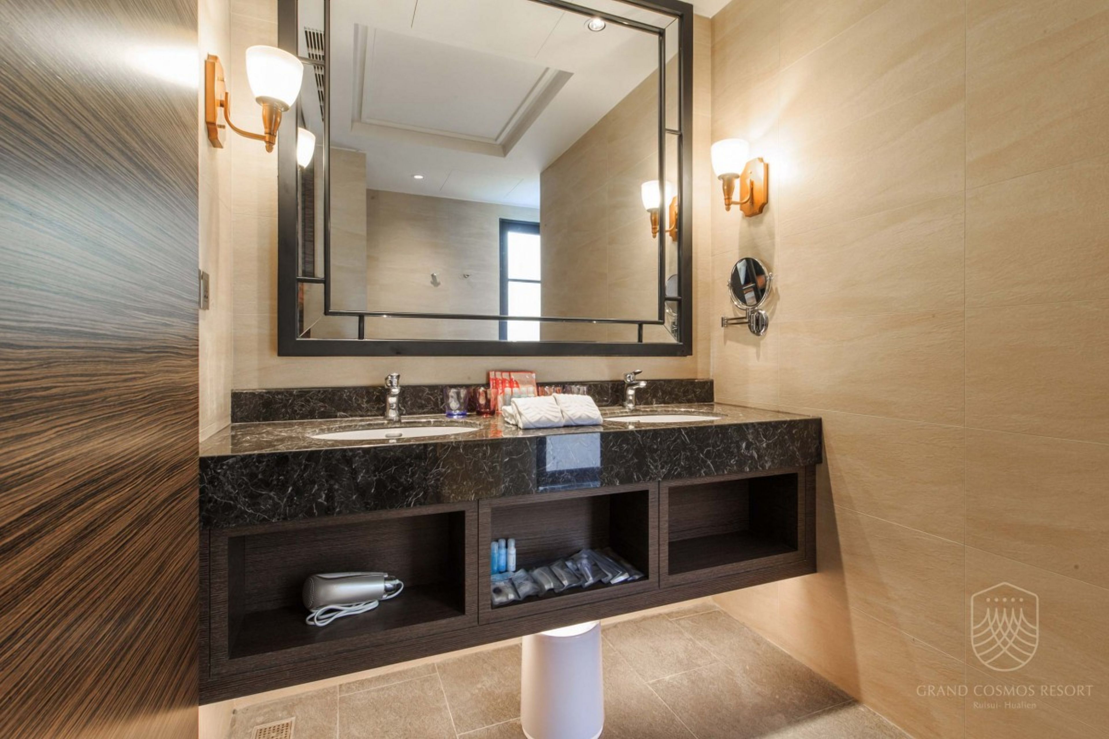 Un baño moderno con un espejo grande, dos lavamanos y estantes empotrados.