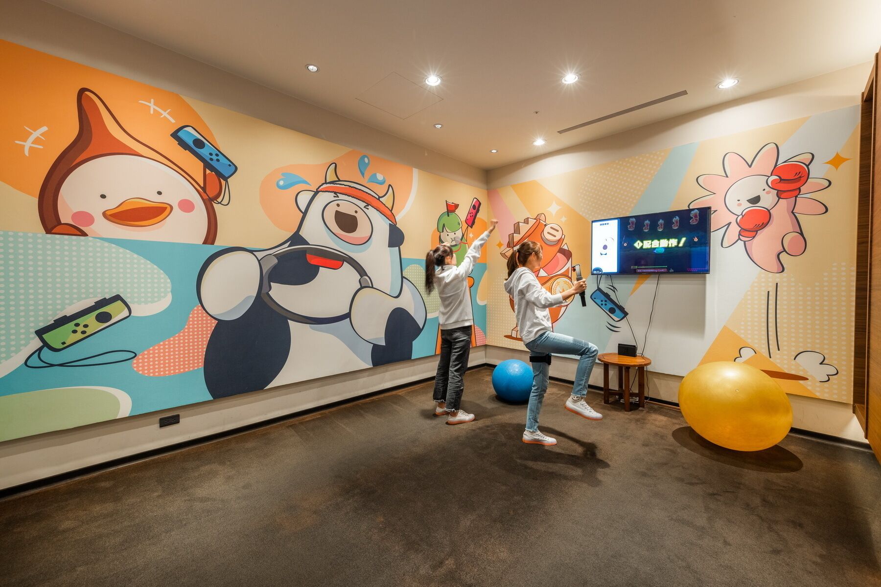 Una pared colorida con personajes de dibujos animados y una pantalla de televisión mostrando un programa.