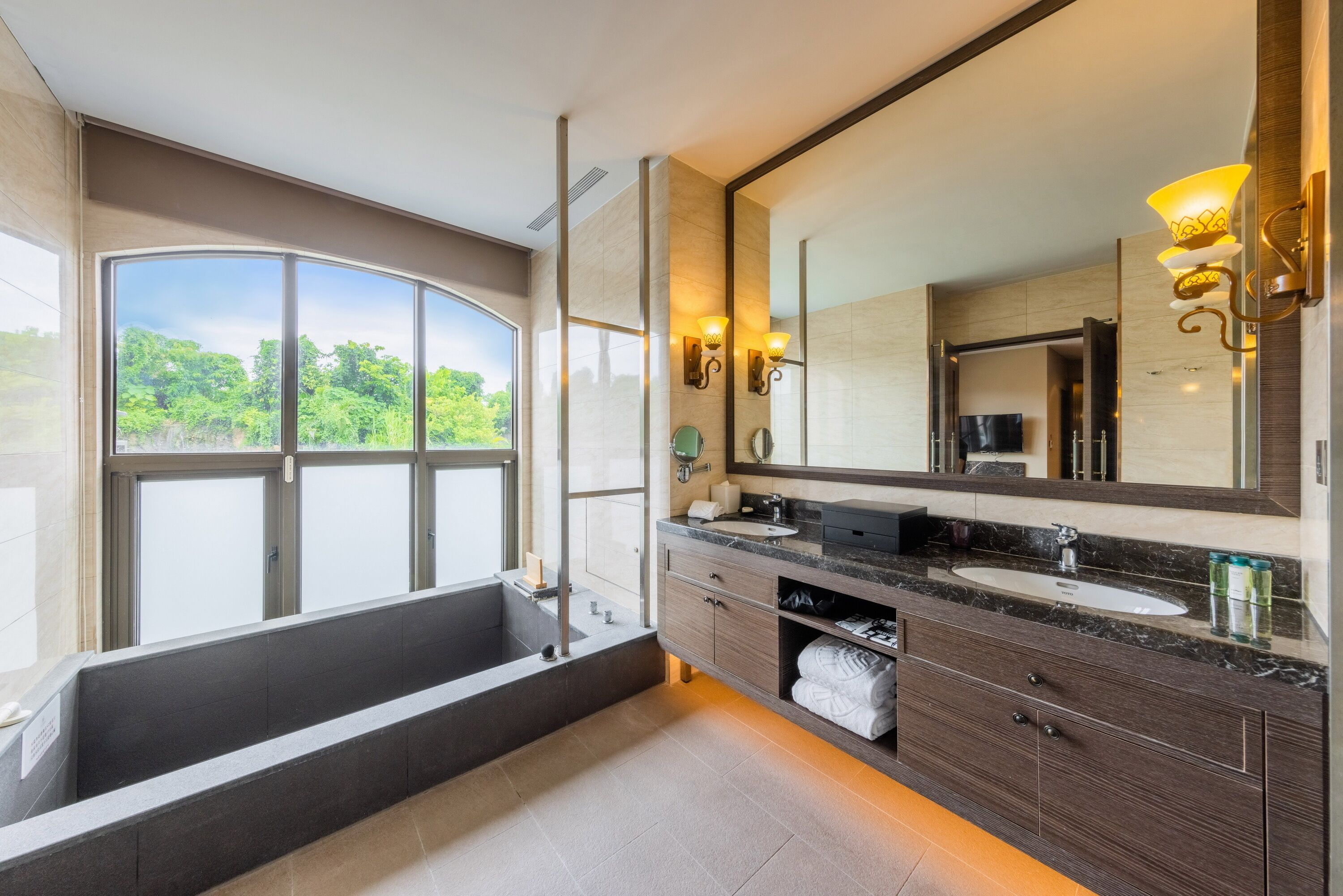 Un baño moderno con una bañera grande, lavamanos dobles y un espejo amplio.