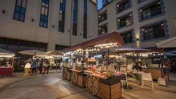 An outdoor market with food stalls and seating areas.