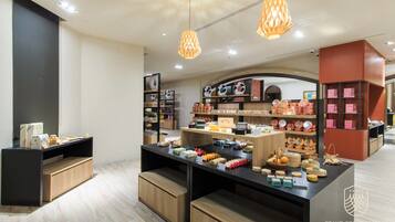 A modern retail space with wooden display counters, hanging lights, and various packaged goods.