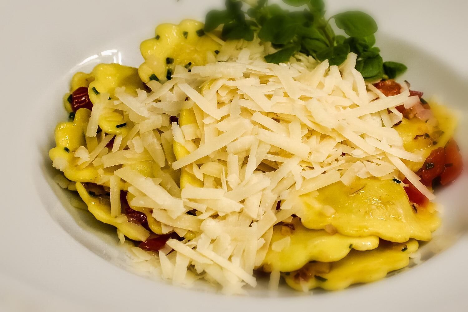 Un plato de pasta con queso y hierbas.