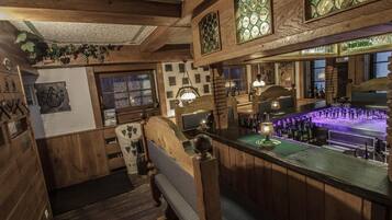 Uma área de bar com decoração em madeira, um balcão com garrafas e um espaço para sentar com um banco.