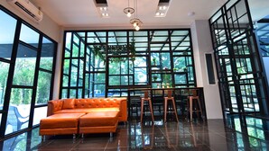 Un interior moderno con ventanas amplias, un sofá de cuero y una zona de comedor.