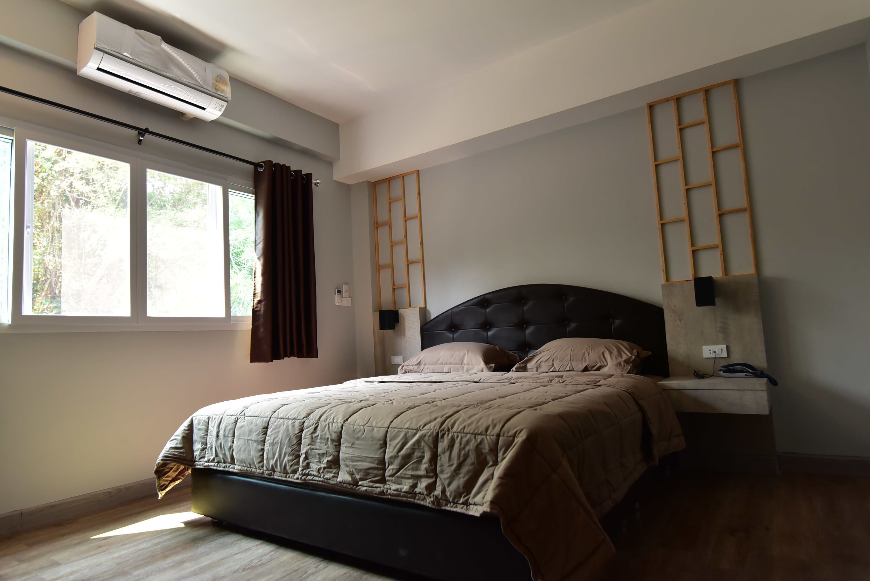 Une chambre à coucher comprenant un lit, une table de chevet, une échelle fixée au mur et un appareil de climatisation.