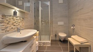 A modern bathroom with a glass-enclosed shower, a white sink, and a toilet. - Ferienwohnung für 1-2 Pers., ca. 49 m²,  1 Schlafzimmer, Wohnraum, Terrasse (Bischofswiesen)