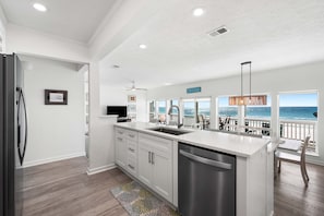A modern kitchen with a large island, stainless steel appliances, and a view of the ocean. - 2 Beach Setups ☀️ 30A Beachfront Panoramic Ocean View, Private Beach w/ Direct Access ☀️ (Santa Rosa Beach)