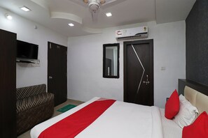 Ein Hotelzimmer mit einem Bett, einem Sofa, einem Fernseher und einer Klimaanlage.