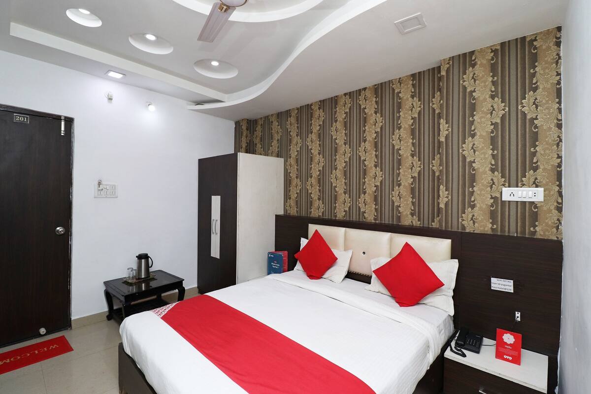 A hotel room with a bed, a nightstand, a wardrobe, and a door labeled 201.