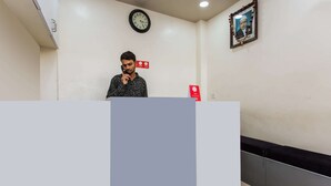 A reception area with a clock on the wall, a framed picture, and a red sign. - OYO 11929 Hotel Ridhi Sidhi (Indore)
