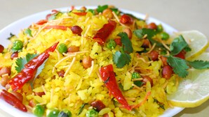 A plate of yellow rice with peas, red chilies, peanuts, and cilantro. - OYO 11929 Hotel Ridhi Sidhi (Indore)