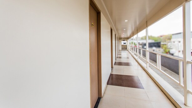 A long, narrow corridor with a tiled floor and a railing on one side. - OYO 11929 Hotel Ridhi Sidhi (Indore)