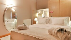 Ein Hotelzimmer mit einem großen Bett, einem runden Spiegel und einer Holzbalkendecke.