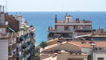 A coastal residential area with multiple buildings, balconies, and a view of the sea.