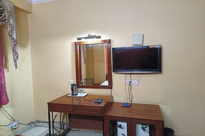 Cozy retreat with a desk, flat-screen TV, and comfortable seating area.