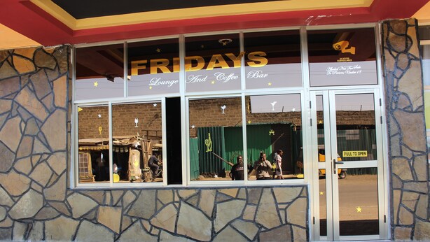 A storefront with a sign reading "FRIDAYS Lounge and Coffee Bar" and a "FULL TO OPEN" sign on the door. - Gees Inn (Nakuru)