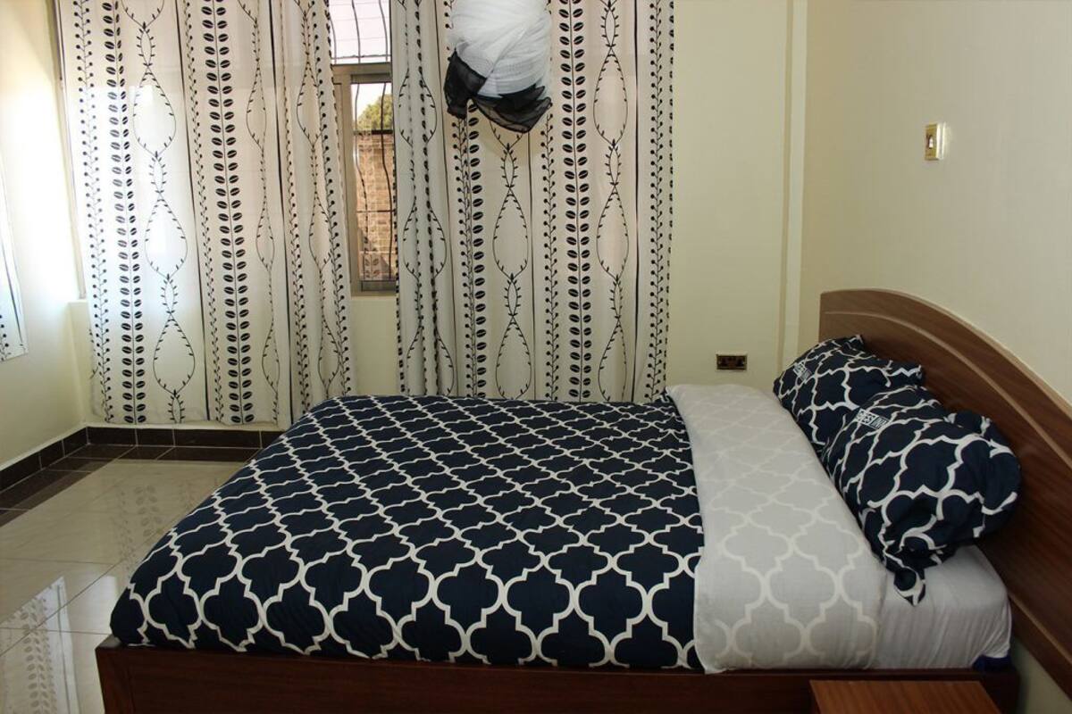 Un dormitorio con cama, cortinas y ventana.