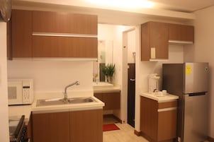 A compact kitchen with a microwave, sink, and refrigerator.