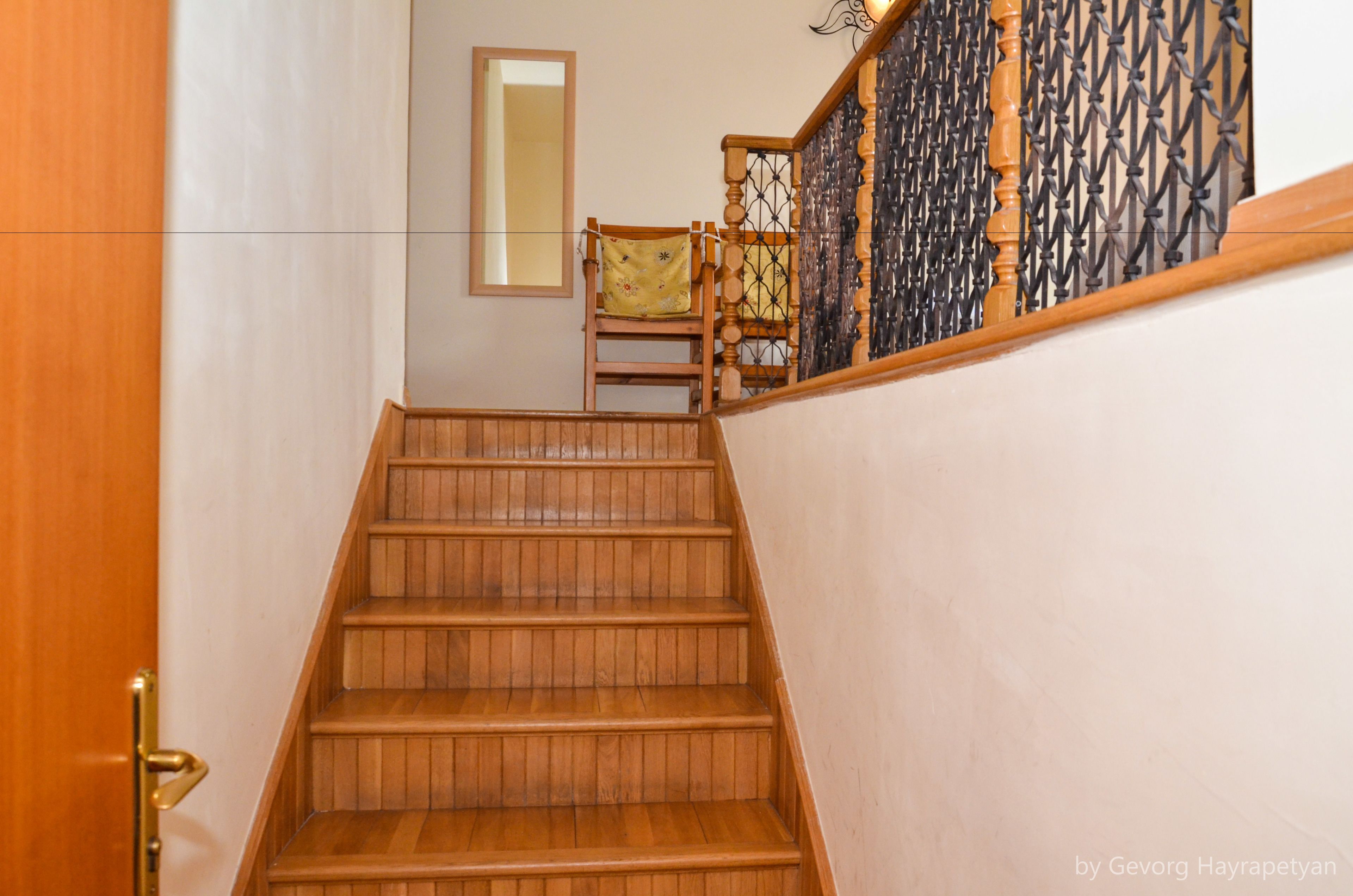 Una escalera de madera con una silla al final.