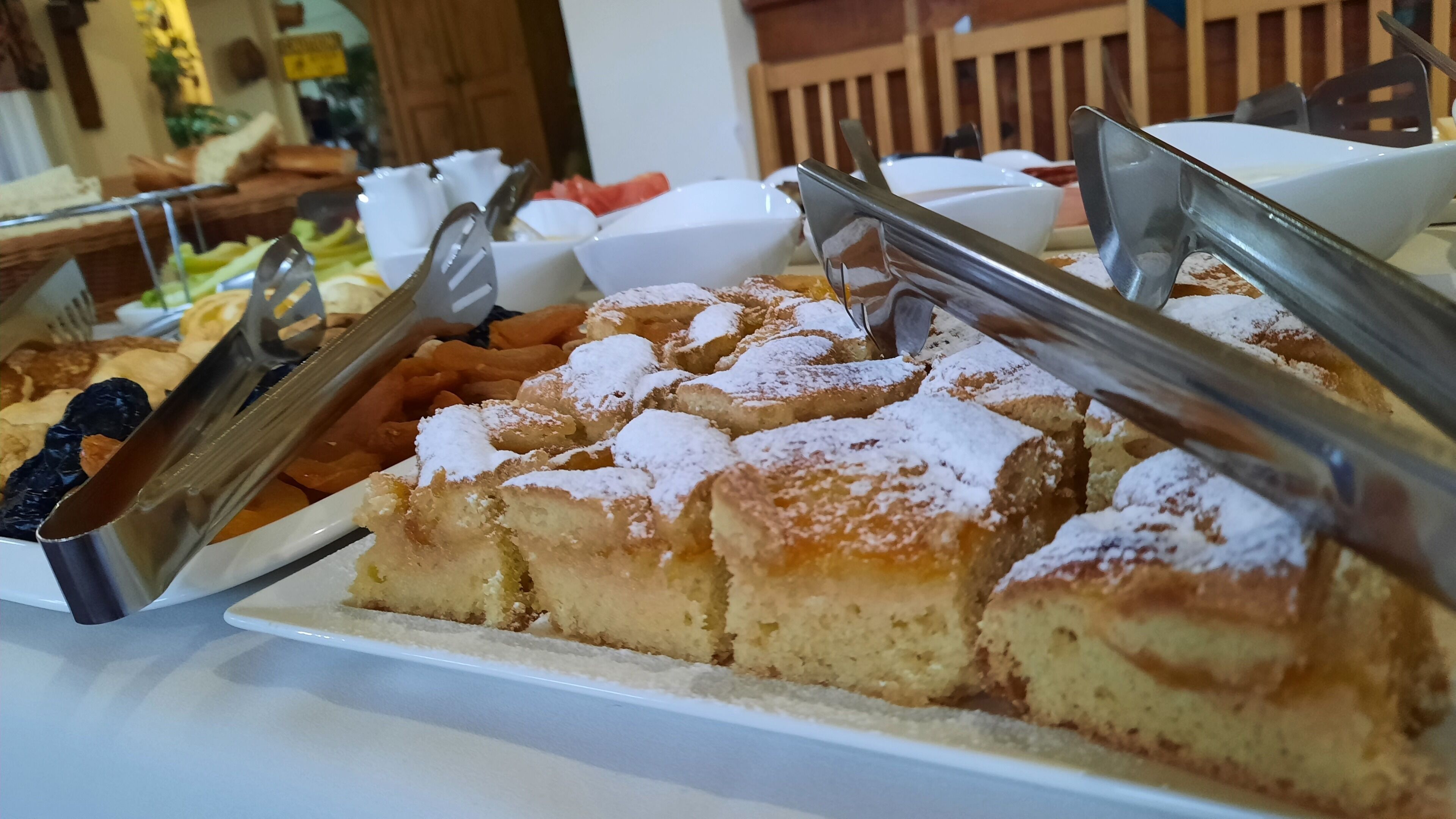 A buffet with various food items including bread and pastries.