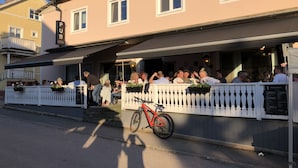 Een restaurant met terras, een fiets voor de deur en een bord dat aangeeft dat het een pub is.