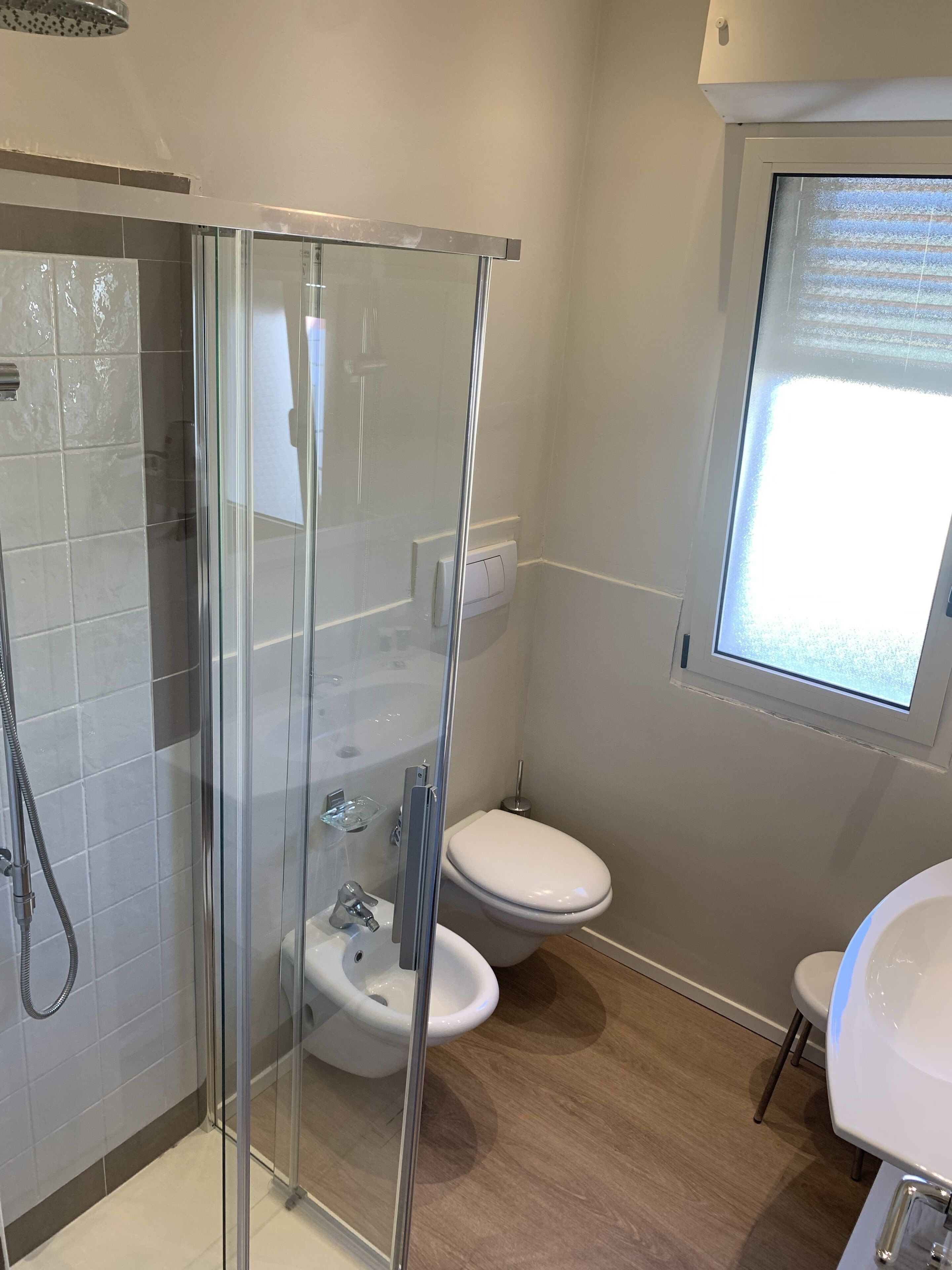 Un baño moderno con ducha de vidrio, inodoro y lavamanos.