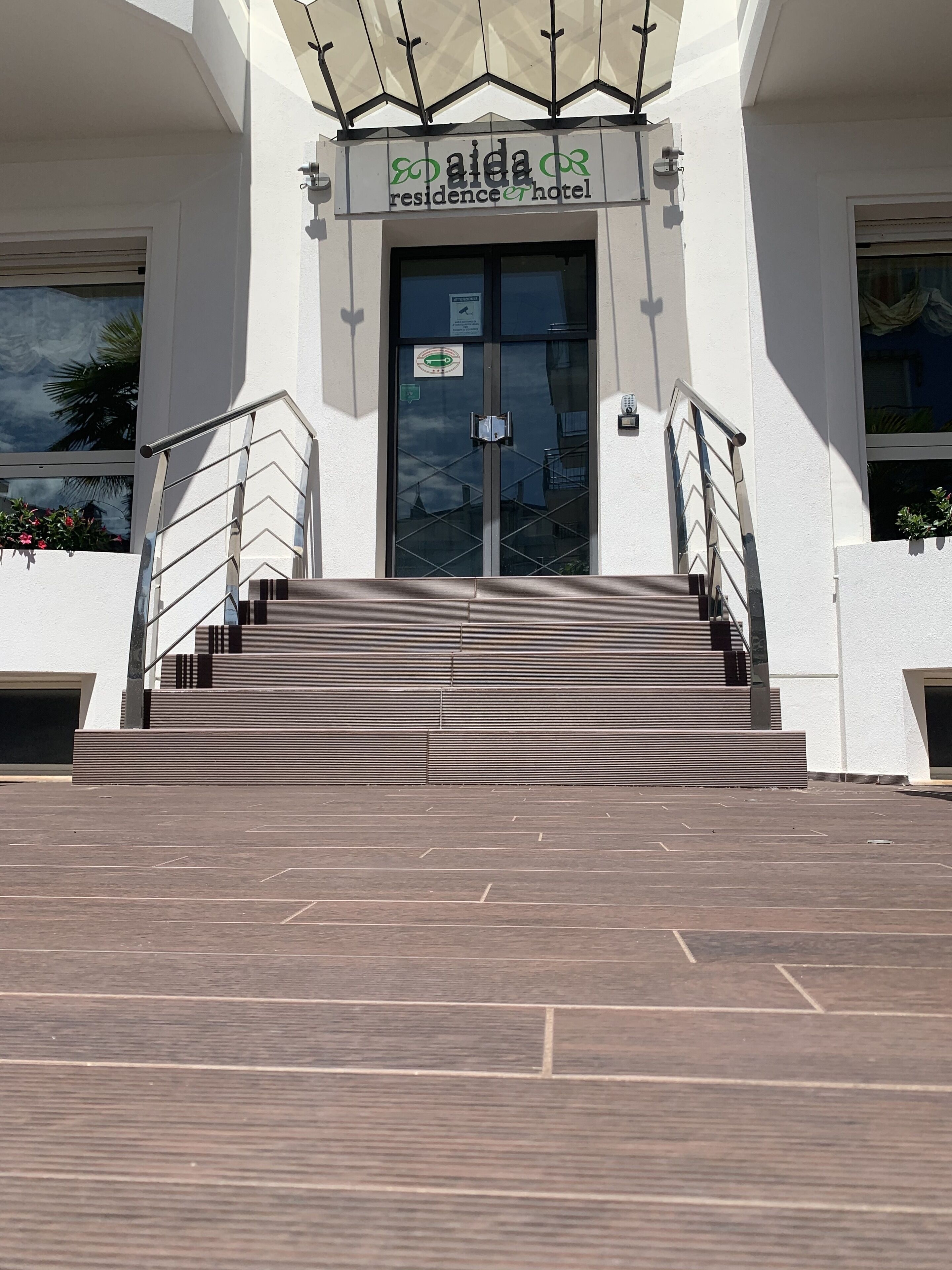 L'ingresso di un edificio con un'insegna che recita 'Aida Residence Hotel'.