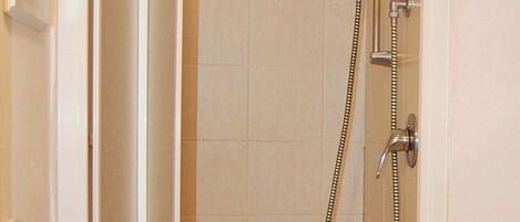 Un baño con ducha, lavamanos e inodoro.