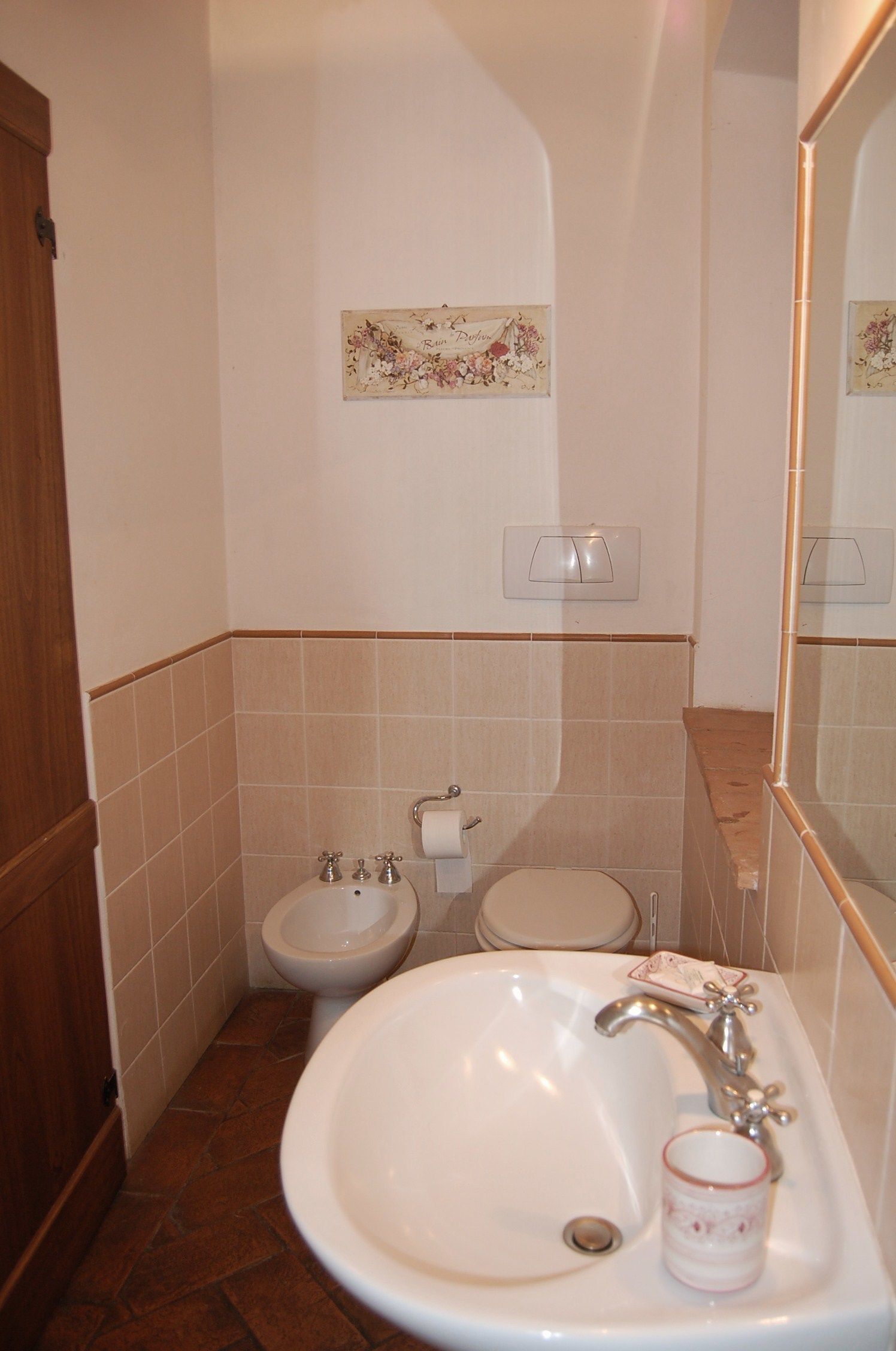 Une salle de bain équipée d’un lavabo, de toilettes, d’un bidet et d’un miroir.