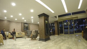 A lobby with a marble floor, a sofa, armchairs, and a large pillar. - Keles Hotel (Rize)